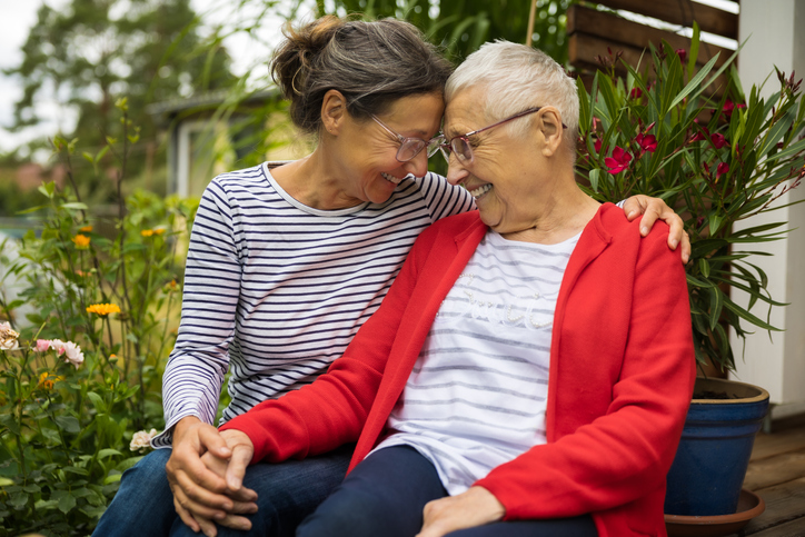 Elderly woman being hugged